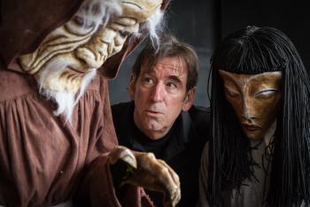 Doug looking at two large masks
