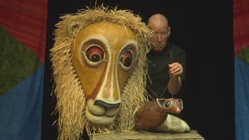 Doug in performance with a lion puppet and mouse puppet
